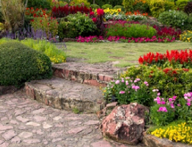 Stone stairs with bright red and yellow flowers in a garden.